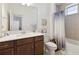 Bathroom showcasing a wood vanity, toilet, and bathtub with modern shower curtain at 3224 Oxbow Ct, Harmony, FL 34773