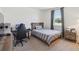 Bedroom with hardwood floors, a gray striped bedspread, black desk, and large window at 3224 Oxbow Ct, Harmony, FL 34773