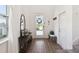 Bright foyer with hardwood floors and decorative console table at 3224 Oxbow Ct, Harmony, FL 34773