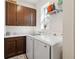 Functional laundry room featuring modern washer and dryer, plus upper and lower cabinets at 3224 Oxbow Ct, Harmony, FL 34773