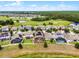 Aerial image featuring homes with fenced yards, pools, and solar panels, set against a backdrop of a golf course at 3420 Middlebrook Pl, Harmony, FL 34773