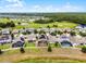Aerial shot of houses featuring pools, solar panels, fenced yards, and a golf course in the background at 3420 Middlebrook Pl, Harmony, FL 34773
