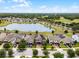 Aerial view of a neighborhood featuring homes with solar panels and views of a lake and golf course at 3420 Middlebrook Pl, Harmony, FL 34773