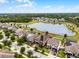 Aerial view featuring a home with solar panels and a lake in a neighborhood with tree-lined streets at 3420 Middlebrook Pl, Harmony, FL 34773