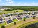 Aerial view showcasing homes with solar panels, screened pools, and landscaping near a lake and golf course at 3420 Middlebrook Pl, Harmony, FL 34773