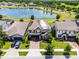 An aerial view of a home with solar panels, a nearby pond, and a manicured lawn at 3420 Middlebrook Pl, Harmony, FL 34773