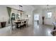 Bright dining room featuring a modern chandelier, a large window, and a stylish dining set for six at 3420 Middlebrook Pl, Harmony, FL 34773