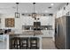 Modern kitchen featuring granite countertops, an island with bar stools, stainless steel appliances, and white cabinetry at 3420 Middlebrook Pl, Harmony, FL 34773
