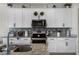 Close-up of modern kitchen showcasing granite countertops, stainless steel appliances, and stylish white cabinetry at 3420 Middlebrook Pl, Harmony, FL 34773