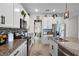 Elegant kitchen featuring granite countertops, stainless steel appliances, and white cabinetry with dark hardware at 3420 Middlebrook Pl, Harmony, FL 34773