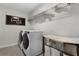 Well-lit laundry room with modern washer and dryer, shelving, and ironing station at 3420 Middlebrook Pl, Harmony, FL 34773