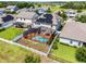 Aerial view of a screened-in pool, solar panels, and white picket fence in a well-maintained backyard at 3420 Middlebrook Pl, Harmony, FL 34773