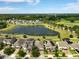 Wide aerial view showcasing homes near a large pond and wooded areas in a well-planned community at 3424 Middlebrook Pl, Harmony, FL 34773