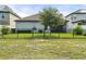 A well-maintained backyard featuring lush green grass, black fence, and view of neighboring homes at 3424 Middlebrook Pl, Harmony, FL 34773