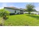 A well-maintained backyard featuring lush green grass, palm tree, and view of the rear of the home at 3424 Middlebrook Pl, Harmony, FL 34773