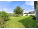 A well-maintained backyard with lush green grass, landscaping, and a view of the pond at 3424 Middlebrook Pl, Harmony, FL 34773