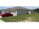 Exterior view of the house featuring a two-car garage and well-maintained lawn at 3476 Yarian Dr, Haines City, FL 33844