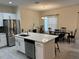 Open-concept kitchen with stainless appliances, island, and adjacent dining area at 3476 Yarian Dr, Haines City, FL 33844
