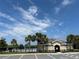 Community pool house with a gated pool, palm trees, and a blue sky with some clouds at 3476 Yarian Dr, Haines City, FL 33844