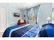 Bright bedroom features blue bedding, a window with natural light, and a cozy red armchair at 3606 Solana Cir, Clermont, FL 34711