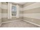 Neutral bedroom with striped walls, carpet flooring, and a window providing natural light at 3606 Solana Cir, Clermont, FL 34711
