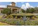 Beautiful clubhouse entrance with a tranquil water fountain, landscaped garden, and welcoming architecture at 3606 Solana Cir, Clermont, FL 34711