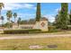 Elegant community clubhouse entrance sign surrounded by lush landscaping and palm trees on a sunny day at 3606 Solana Cir, Clermont, FL 34711