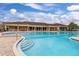 A sparkling community pool with steps leads up to lounge chairs on a brick deck at 3606 Solana Cir, Clermont, FL 34711