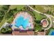 Aerial view of a resort-style community pool, lounge chairs, and lush landscaping on a sunny day at 3606 Solana Cir, Clermont, FL 34711