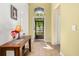 Inviting foyer features tile flooring, a charming console table with flowers, and natural light streaming through the front door at 3606 Solana Cir, Clermont, FL 34711