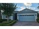 Charming single-story blue home with a brick driveway, attached garage, and manicured landscaping at 3606 Solana Cir, Clermont, FL 34711