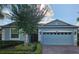 Charming single-story blue home with a brick driveway, attached garage, and manicured landscaping at 3606 Solana Cir, Clermont, FL 34711