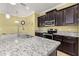 Charming kitchen featuring granite counters, dark wood cabinetry and stainless steel appliances at 3606 Solana Cir, Clermont, FL 34711