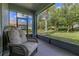 Enclosed patio features wicker chair, peaceful outdoor view with lush greenery and natural light at 3606 Solana Cir, Clermont, FL 34711