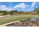 Lush putting green landscaped with native plants, framed by a mulch bed, offering a private golf experience at 3606 Solana Cir, Clermont, FL 34711