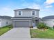 Two-story home with gray siding, white shutters, a two-car garage, and a well-manicured lawn at 3926 Palazzo Pl, Winter Haven, FL 33884