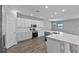 This kitchen boasts white cabinets, quartz countertops, stainless steel appliances, and laminate flooring at 3926 Palazzo Pl, Winter Haven, FL 33884