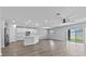 Open-concept living space with a modern kitchen featuring white cabinets, an island, and sleek flooring at 3926 Palazzo Pl, Winter Haven, FL 33884
