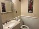 Well-lit bathroom features a sink, toilet, mirror, wainscoting and novelty art at 416 Howard Ave # D, Lakeland, FL 33815