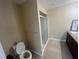 Neutral bathroom with tiled floors, a walk-in shower, toilet and granite vanity with a dark wood finish at 416 Howard Ave # D, Lakeland, FL 33815
