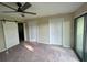 Bedroom featuring neutral carpeting, sliding barn door and a ceiling fan at 416 Howard Ave # D, Lakeland, FL 33815