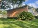 Well-kept exterior featuring a brick facade, manicured landscaping, and a bright lawn at 416 Howard Ave # D, Lakeland, FL 33815