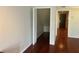 Hallway features wood floors, white walls, closet space, and a door at the end of the hall at 416 Howard Ave # D, Lakeland, FL 33815