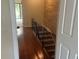 Hallway features wood floors, a wood accent wall, and stairs with a black railing leading up to the next floor at 416 Howard Ave # D, Lakeland, FL 33815