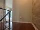 Hallway with wood floors and railing leading to a carpeted area at 416 Howard Ave # D, Lakeland, FL 33815