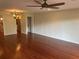 Open living room with shiny wood floors, ceiling fan, and open access to other rooms at 416 Howard Ave # D, Lakeland, FL 33815