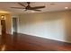 Spacious living room features shiny wood floors, a ceiling fan, and open access to the kitchen at 416 Howard Ave # D, Lakeland, FL 33815