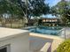 Community pool surrounded by lounge chairs, trees, and fencing, perfect for relaxation at 416 Howard Ave # D, Lakeland, FL 33815