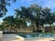 Community pool with clear water, surrounded by mature trees and seating, perfect for relaxation and recreation at 416 Howard Ave # D, Lakeland, FL 33815