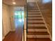 Elegant staircase with wood treads and white risers, complemented by hardwood flooring and natural light at 416 Howard Ave # D, Lakeland, FL 33815
